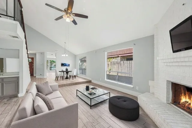 a living room with furniture a flat screen tv and a fireplace