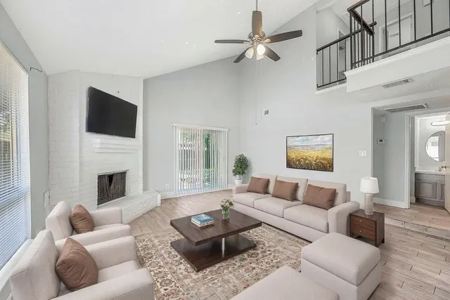 a living room with furniture a fireplace and a flat screen tv