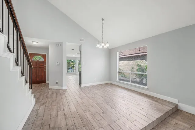 a view of a livingroom with wooden floor and stairs