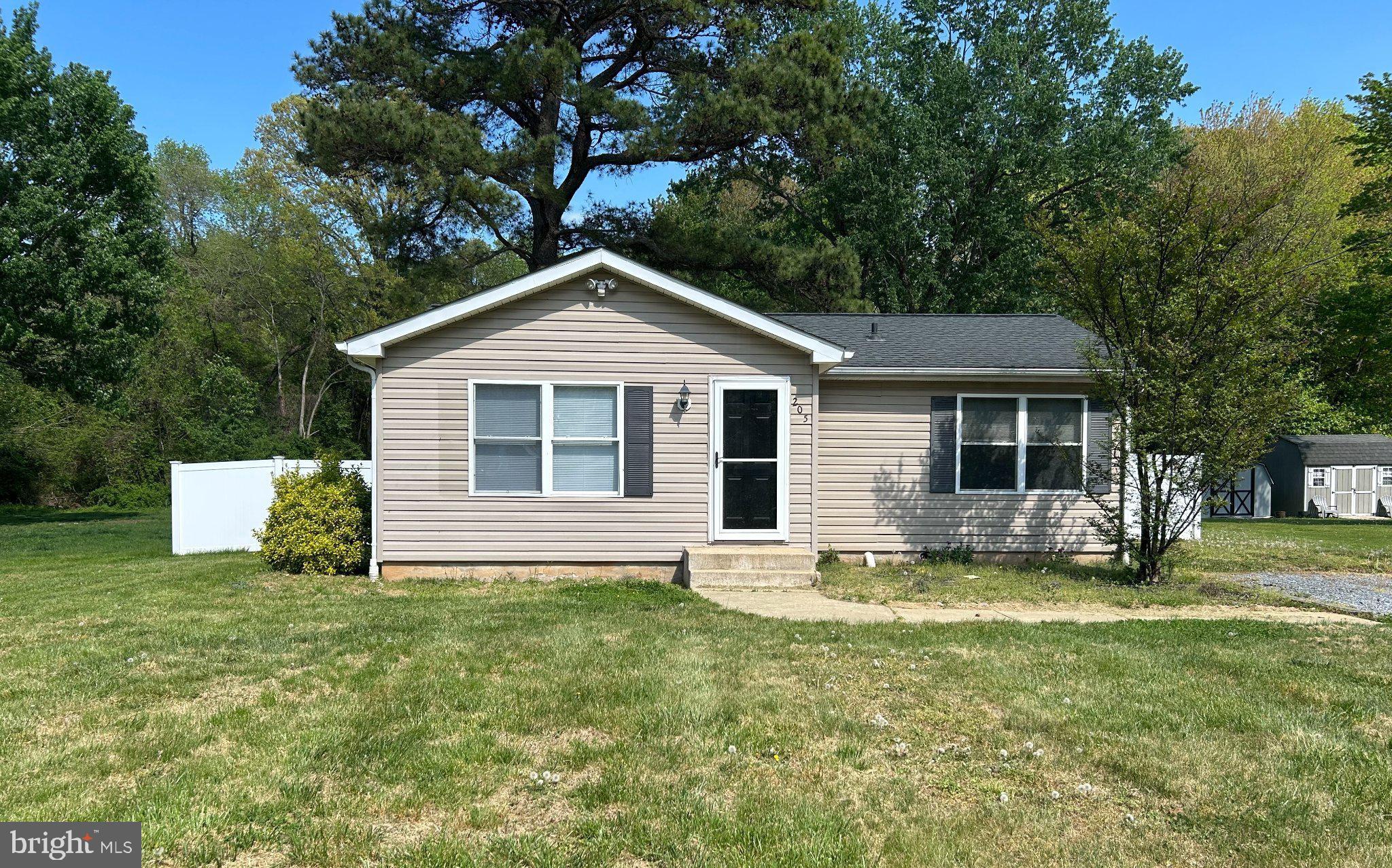 205 Gravel Run Road Grasonville, MD 21638 - Photo 1 of 1 a front view of a house with a garden and trees