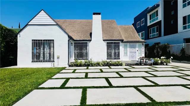 a view of white house with a yard and sitting area