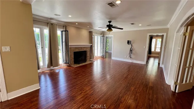 a view of empty room with wooden floor and fireplace