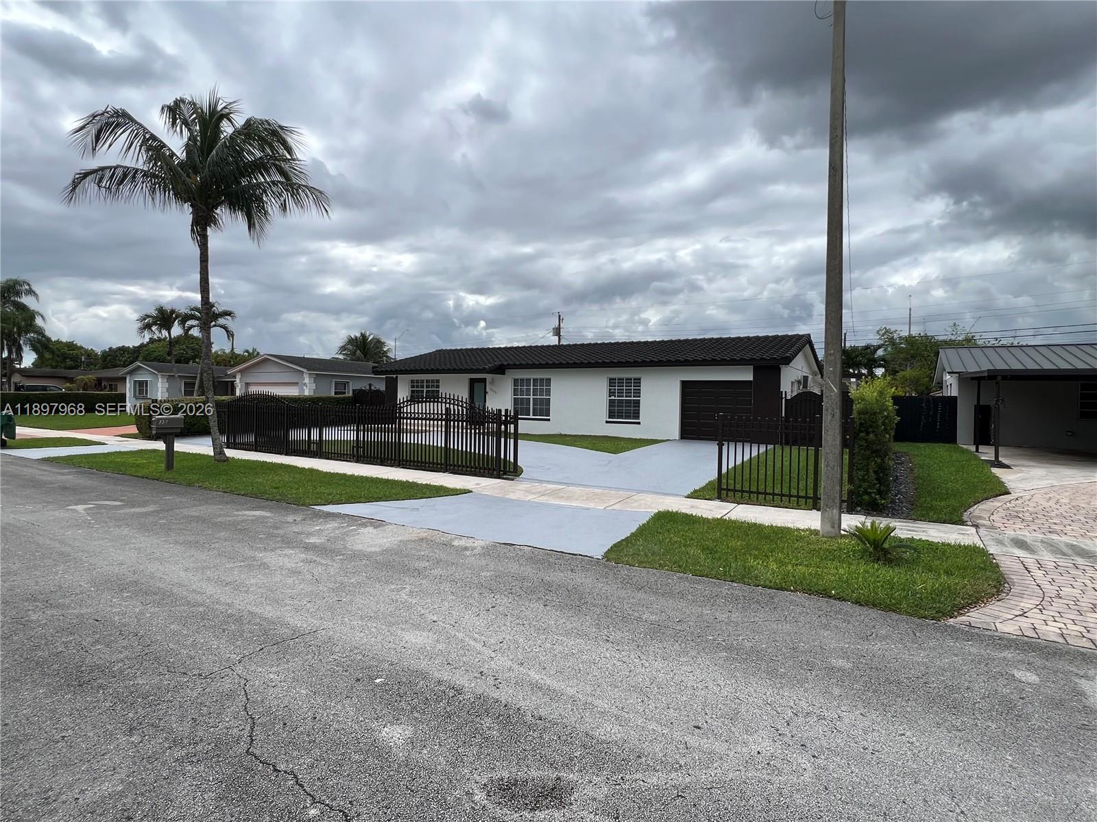 3530 Southwest 126th Avenue Miami, FL 33175 - Photo 2 of 52 a view of a house with a yard and palm trees