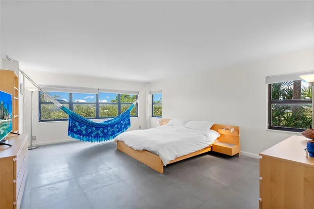 a bedroom with a bed and a large window