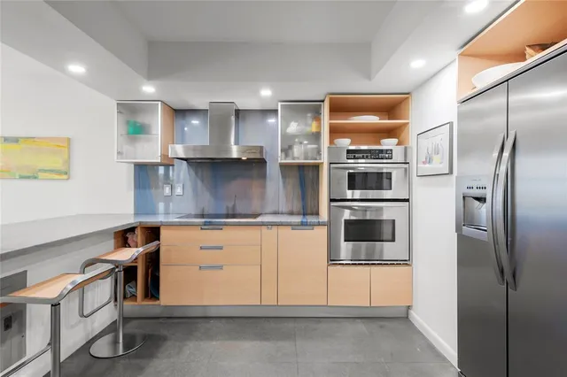 a kitchen with stainless steel appliances granite countertop a refrigerator and a stove