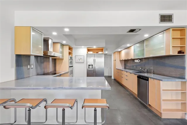 a large kitchen with stainless steel appliances kitchen island a large counter top
