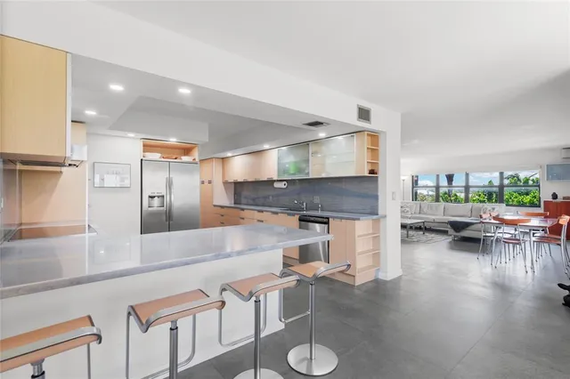 a large kitchen with stainless steel appliances granite countertop a sink and a refrigerator