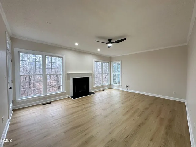 a view of an empty room with a fireplace and a window