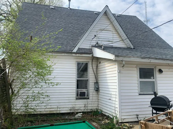 a view of house with backyard and sitting area