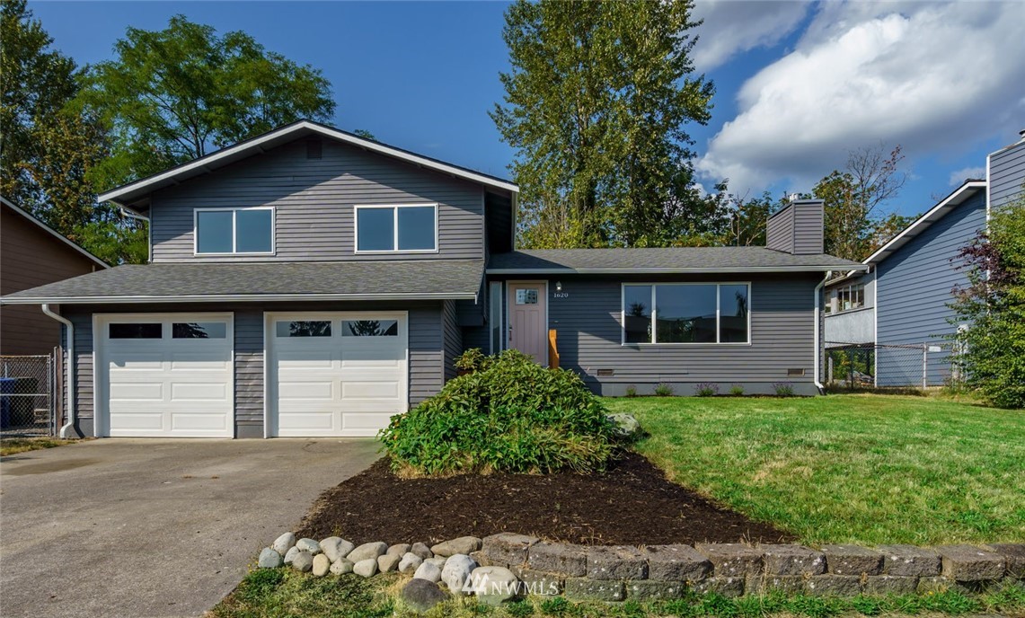 a front view of a house with a yard and garage