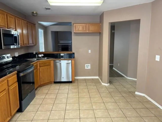 a kitchen with stainless steel appliances granite countertop a stove a sink and a refrigerator