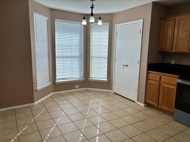 a view of an empty room with window and cabinet
