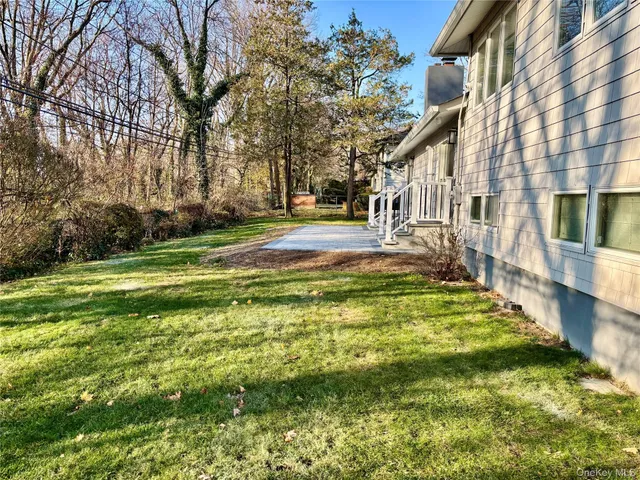 a view of a house with a big yard and large trees