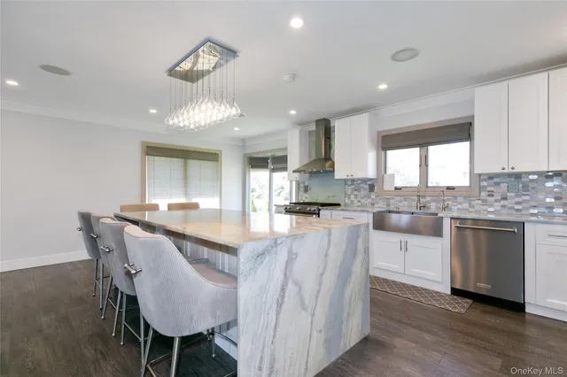 a kitchen with stainless steel appliances granite countertop a stove a sink a refrigerator dining table and chairs