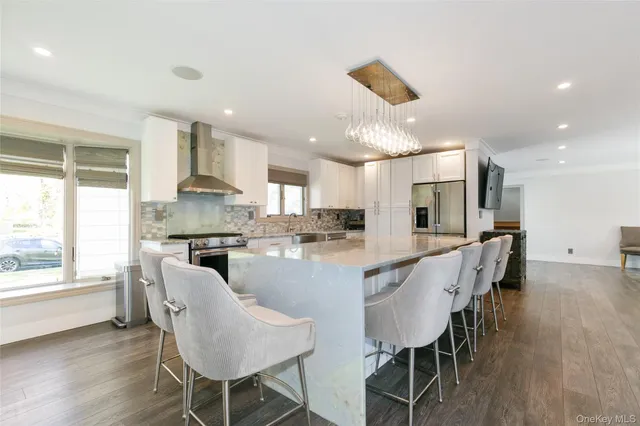 a large kitchen with kitchen island a large counter top appliances and furniture