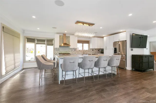 a large dining room with kitchen island furniture a large window and a fireplace