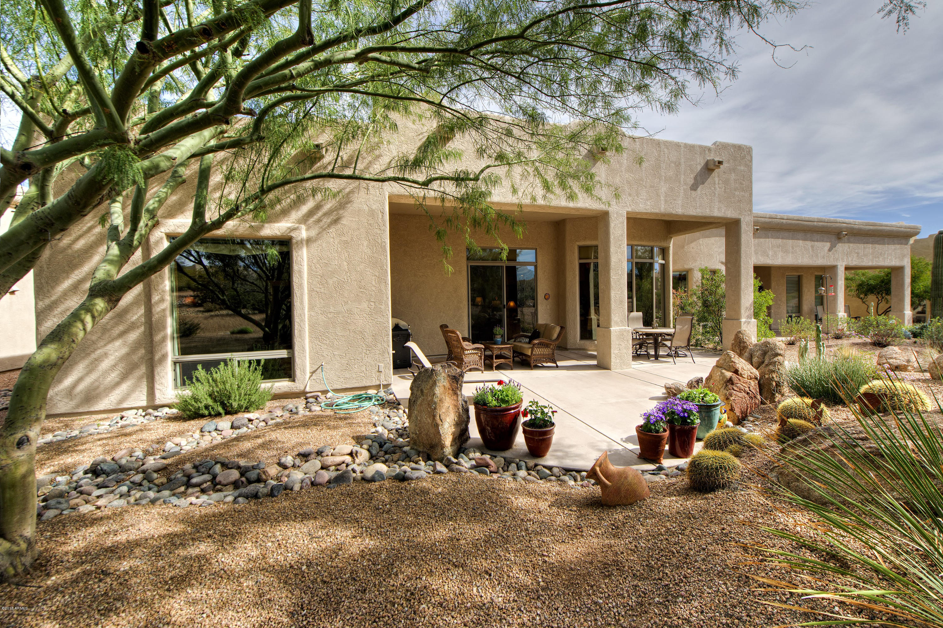 27822 North Quail Spring Road Rio Verde, AZ 85263 - Photo 20 of 33 a view of a brick house with large windows and couches