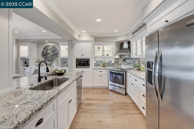 a kitchen with kitchen island granite countertop a sink stainless steel appliances and cabinets