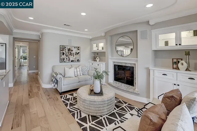 a living room with furniture a fireplace and a wooden floor