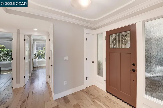 a view of a hallway with wooden floor and a bathroom