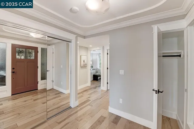 a view of a hallway with wooden floor and closet