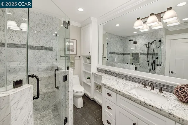 a bathroom with a granite countertop sink mirror and shower