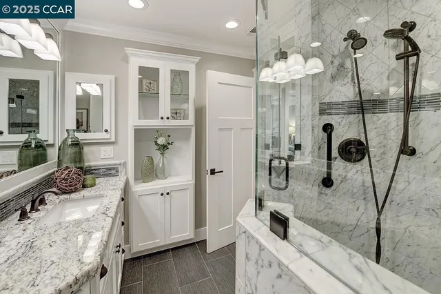 a bathroom with a granite countertop sink a toilet a mirror and shower