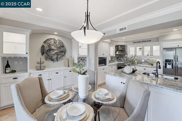 a very nice looking dining room with stainless steel appliances furniture a window and kitchen view