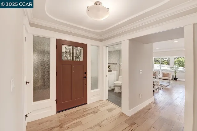 a view of a hallway with bathroom and wooden floor