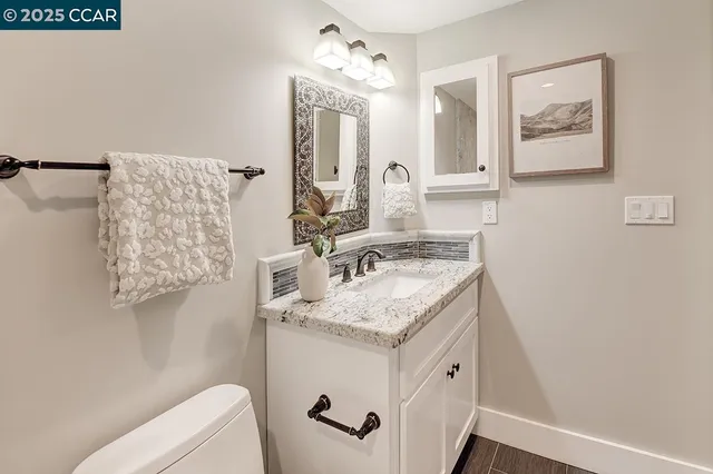 a bathroom with a granite countertop sink and a mirror