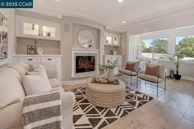 a living room with furniture a fireplace and a window