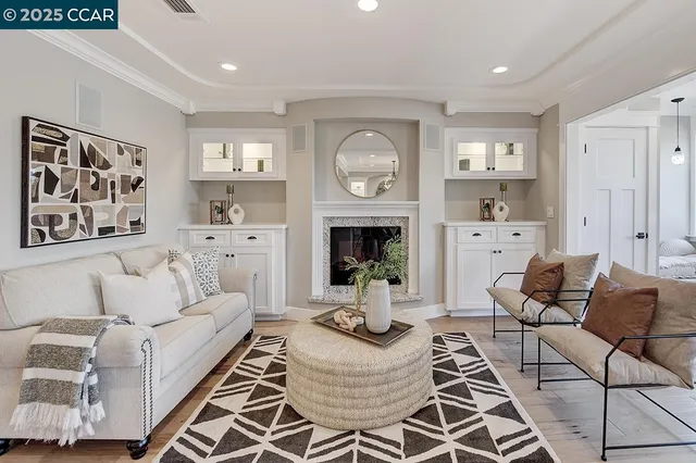 a living room with furniture a fireplace and a large mirror