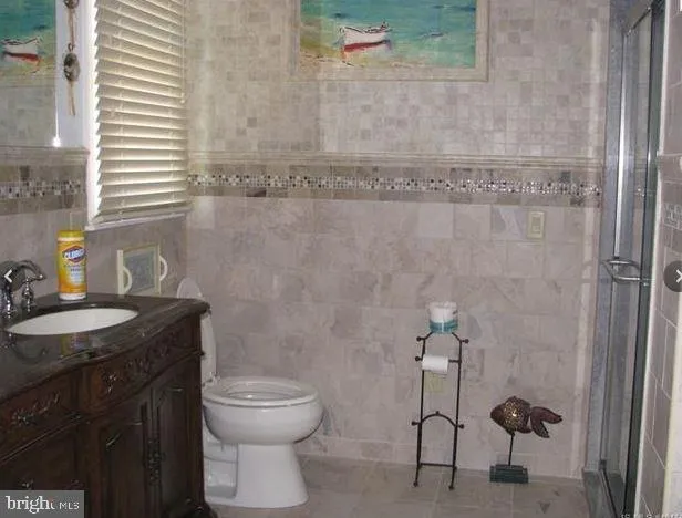 a bathroom with a granite countertop toilet a sink and mirror