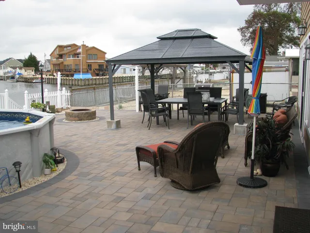a view of a patio with dining table and chairs under an umbrella