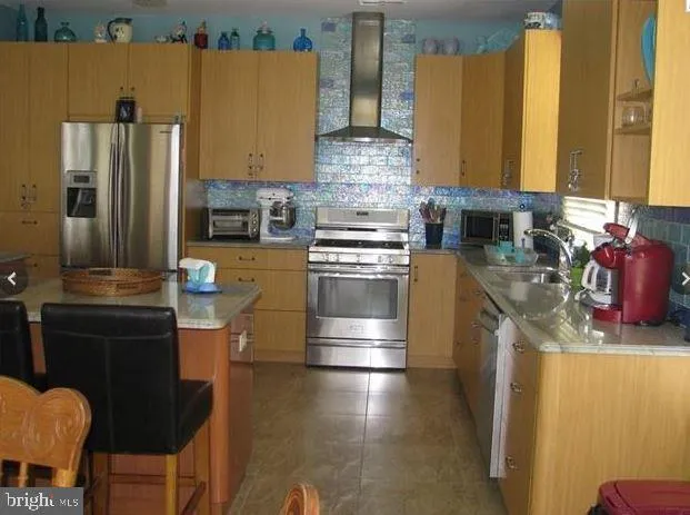a kitchen with stainless steel appliances granite countertop a sink a stove and a refrigerator