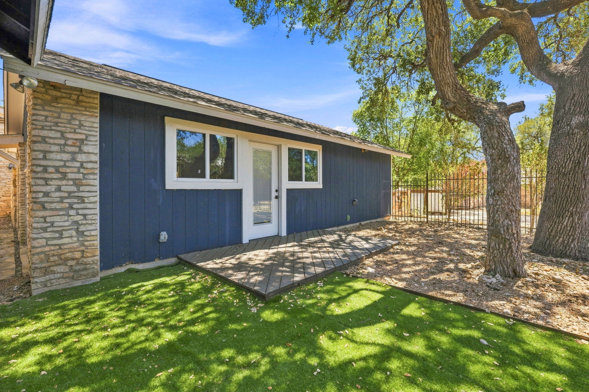 3809 Wyldwood Road Austin, TX 78739 - Photo 29 of 40 Mature trees shade a private backyard featuring stone accents and a small patio deck.