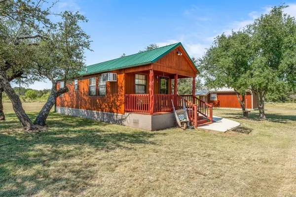 a view of a house with a yard and a tree
