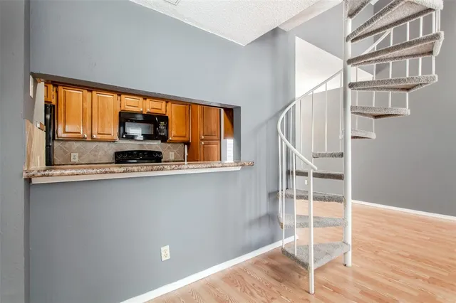 a kitchen with granite countertop a refrigerator and a stove top oven