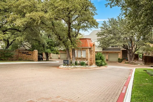 a front view of a house with a yard and large trees