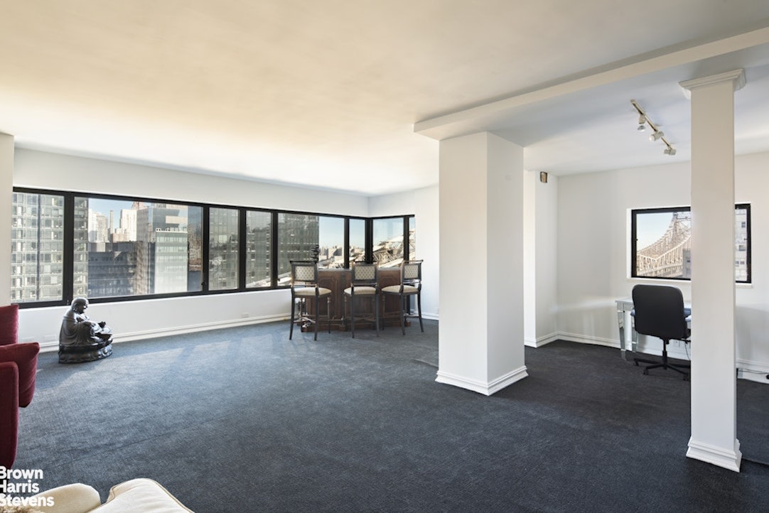 425 East 58th Street, Unit 16AB Manhattan, NY 10022 - Photo 11 of 18 a living room with furniture and large windows