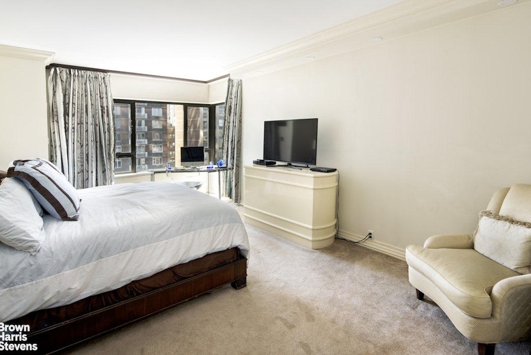 425 East 58th Street, Unit 16AB Manhattan, NY 10022 - Photo 3 of 18 a spacious bedroom with a bed and a flat screen tv