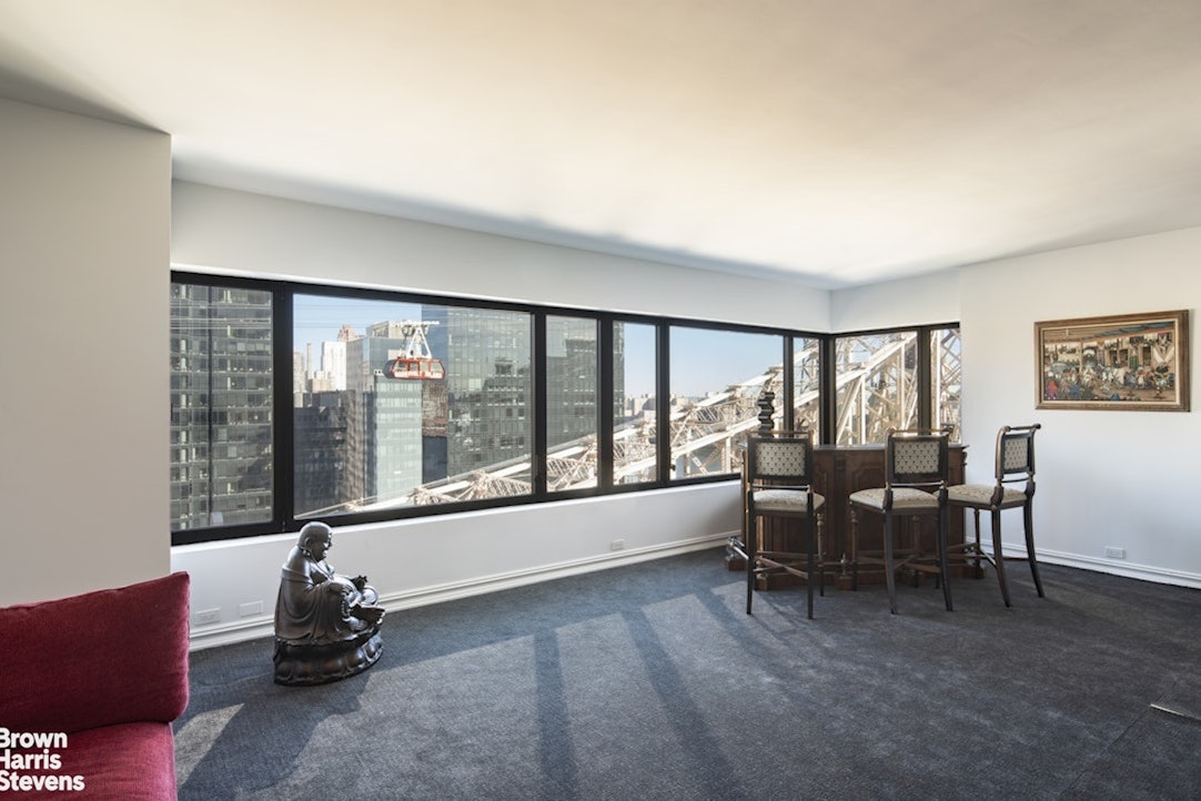 425 East 58th Street, Unit 16AB Manhattan, NY 10022 - Photo 7 of 18 a living room with furniture and a floor to ceiling window