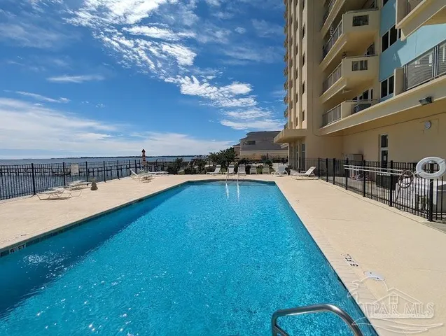 a view of a swimming pool with an outdoor seating and a shower