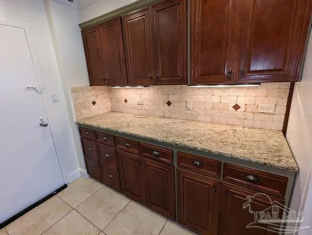 a kitchen with granite countertop a sink a stove and cabinets
