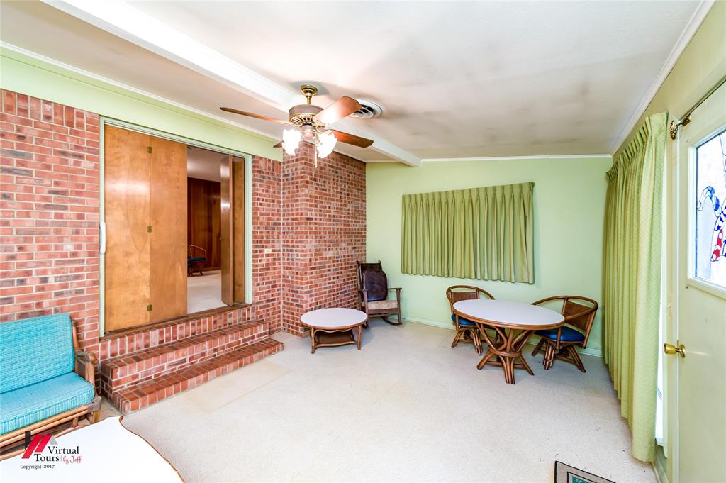 205 7th Street Northeast Springhill, LA 71075 - Photo 24 of 40 Brick wall accents, ceiling fan, wood-finish sliding doors, and a stained-glass window panel