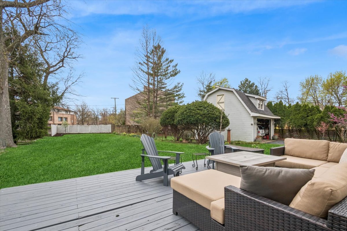 291 Lionel Road Riverside, IL 60546 - Photo 23 of 32 a view of a patio with couches and table and chairs with wooden fence and floor