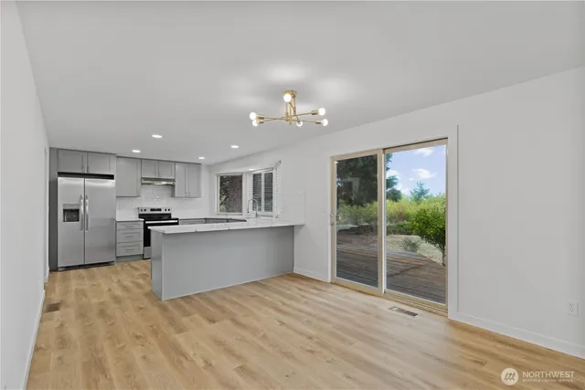 a large kitchen with stainless steel appliances granite countertop a stove sink and cabinets