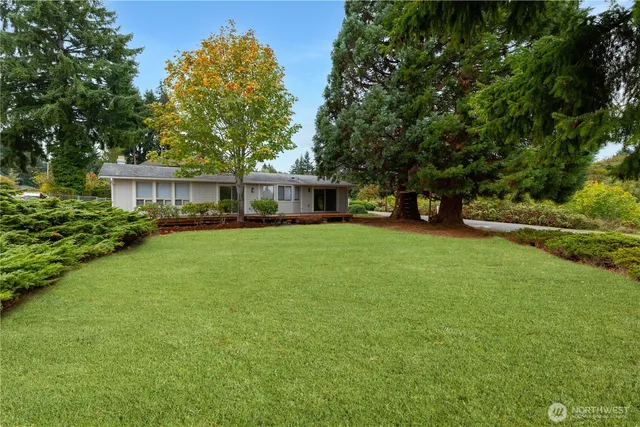 a view of a house with a big yard and large trees