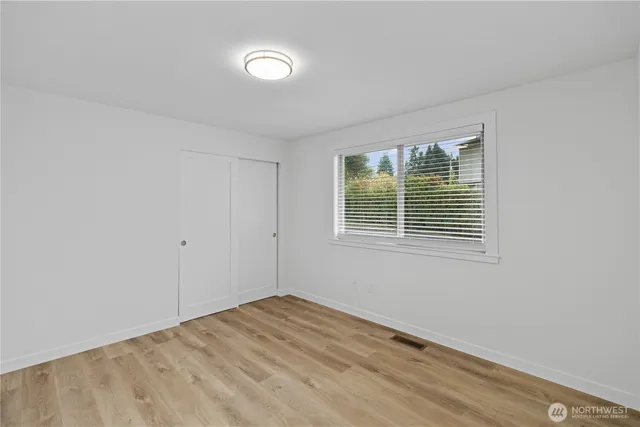 a bedroom with a large bed and a wooden floor