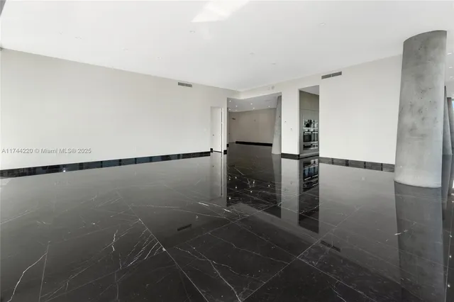 a view of an empty room with large windows